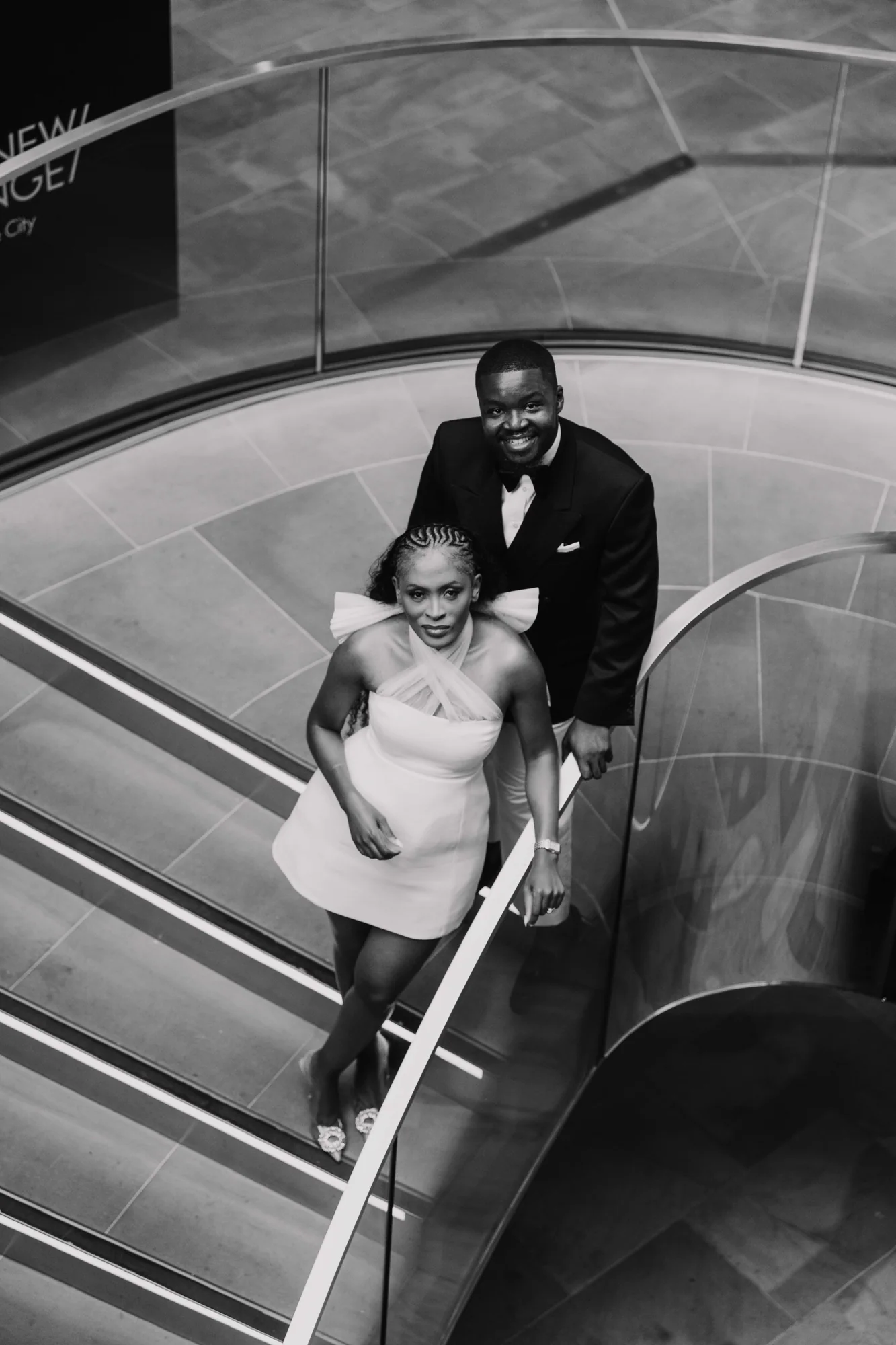 A black-and-white portrait of Kennedy and Didimalang on a curved staircase