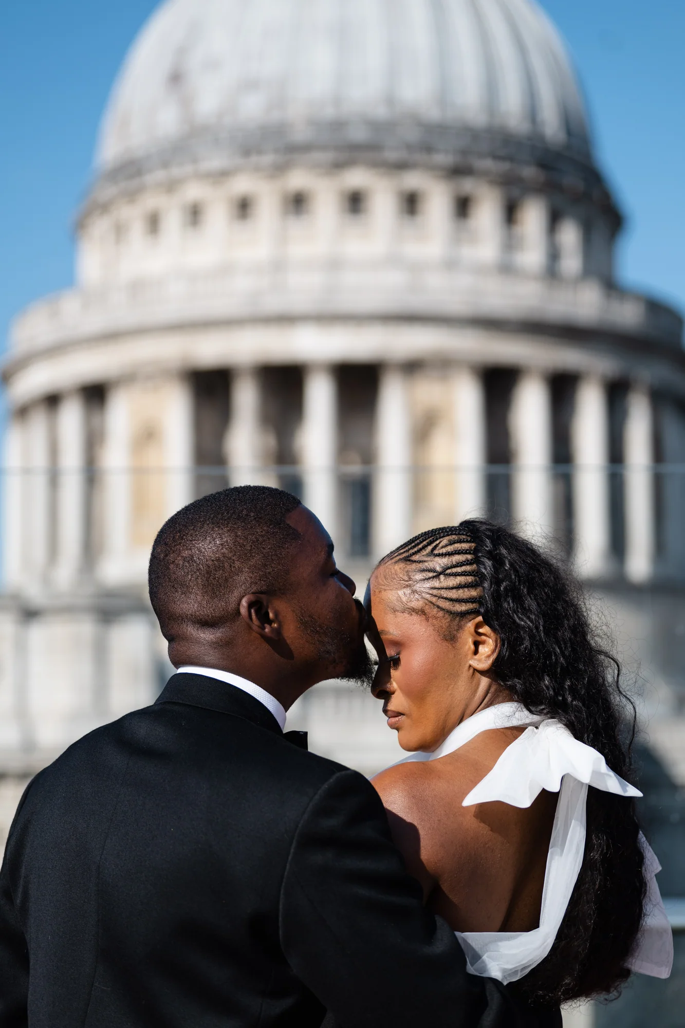 Kennedy kissing Didimalang's forehead with St Paul's Cathedral behind them
