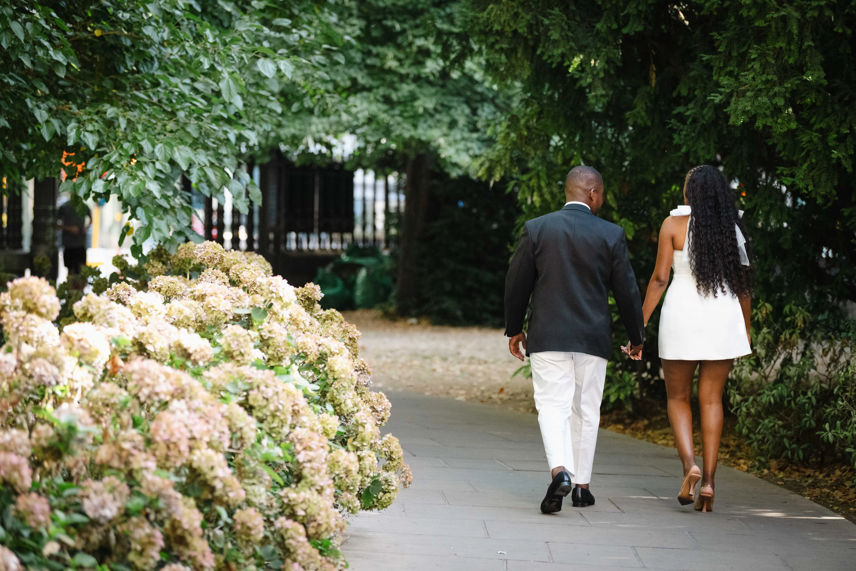 Kennedy and Didimalang walking hand in hand away along the garden path